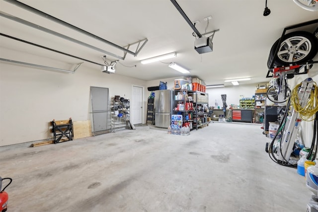 garage featuring a garage door opener and freestanding refrigerator