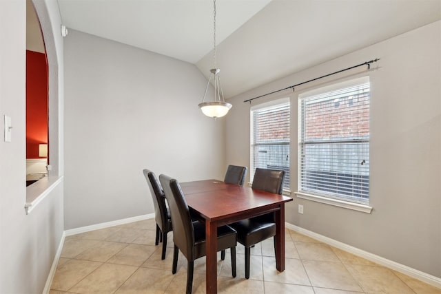 dining room with light tile patterned floors, baseboards, and vaulted ceiling