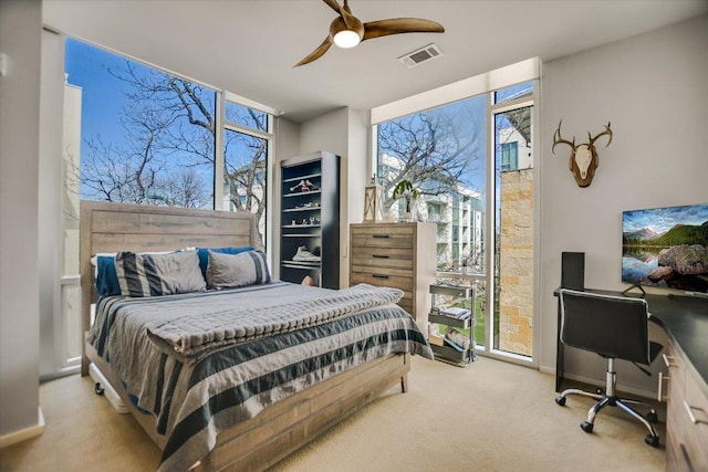 bedroom featuring visible vents, baseboards, ceiling fan, expansive windows, and carpet flooring