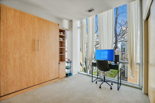 carpeted office space with floor to ceiling windows and visible vents