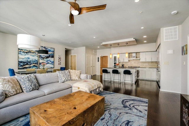 living room with baseboards, visible vents, dark wood finished floors, recessed lighting, and ceiling fan