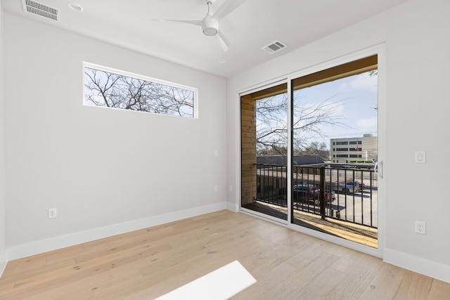 unfurnished room featuring visible vents, baseboards, and wood finished floors