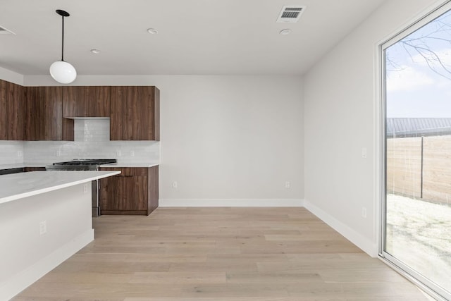 609 Hammack Dr Unit 2, Austin, TX 78752 - kitchen with healthy amount of natural light, light countertops, decorative backsplash, and light wood finished floors