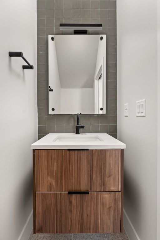 bathroom with backsplash, vanity, and baseboards