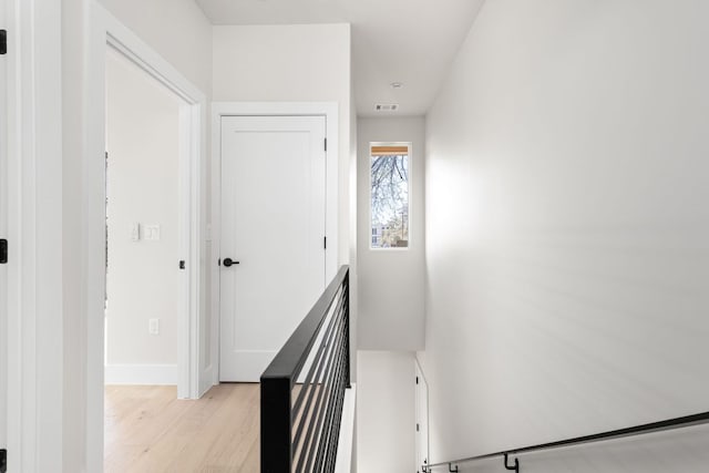 staircase with visible vents, baseboards, and wood finished floors