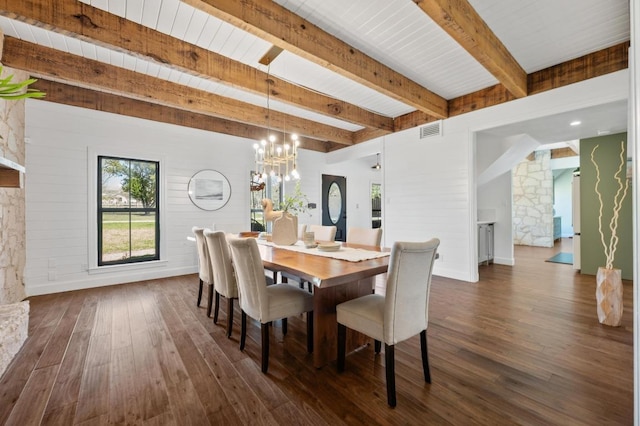 dining area featuring visible vents, dark wood finished floors, an inviting chandelier, beam ceiling, and a stone fireplace