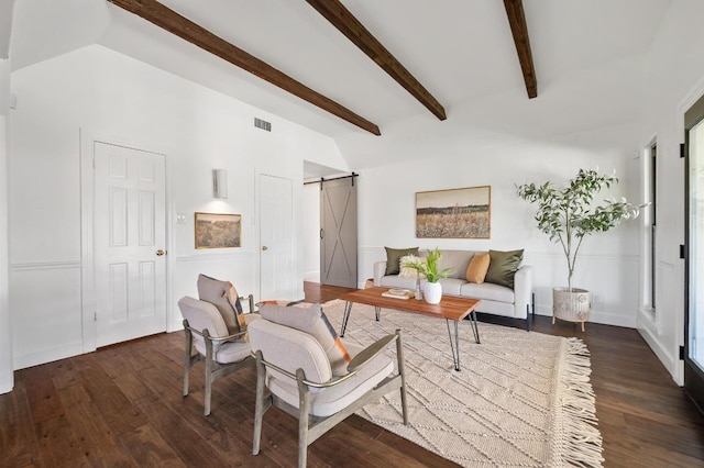 living room with a barn door, vaulted ceiling with beams, wood finished floors, and visible vents