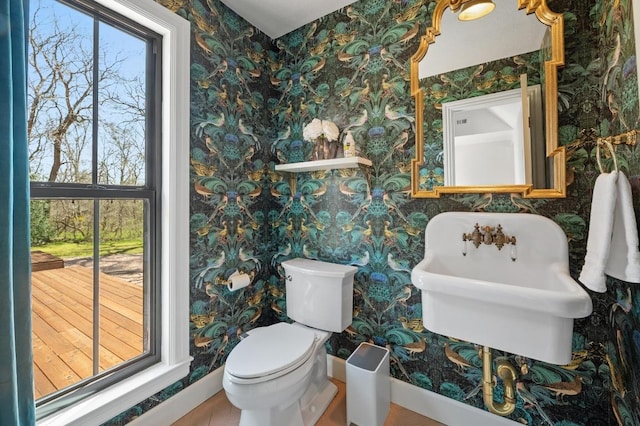 half bathroom with toilet and wallpapered walls