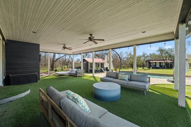 view of patio with outdoor lounge area, an outbuilding, and a ceiling fan