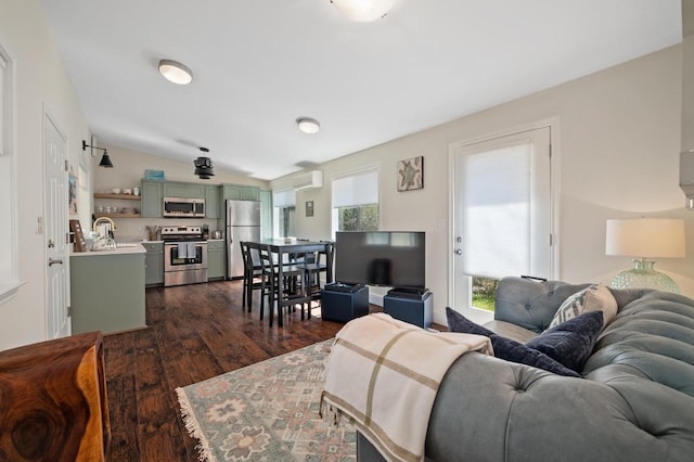 living area featuring dark wood-type flooring, a wall unit AC, and lofted ceiling