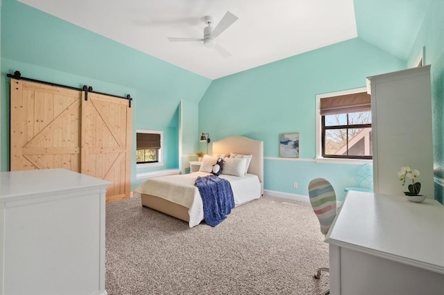 bedroom featuring a barn door, baseboards, carpet flooring, lofted ceiling, and ceiling fan