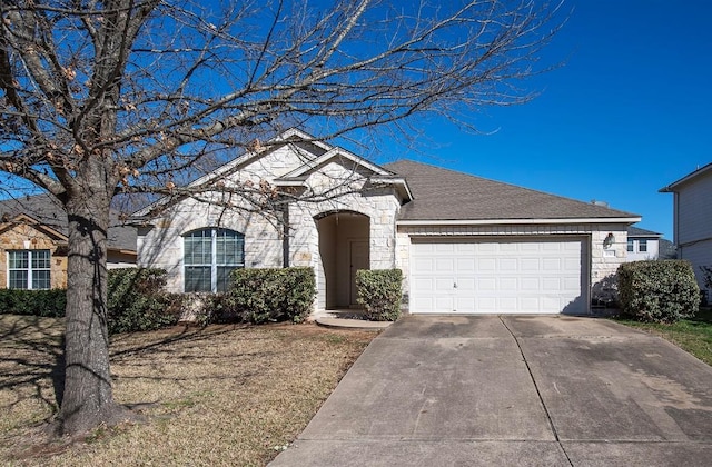 view of front of house with a garage, stone siding, roof with shingles, and concrete driveway