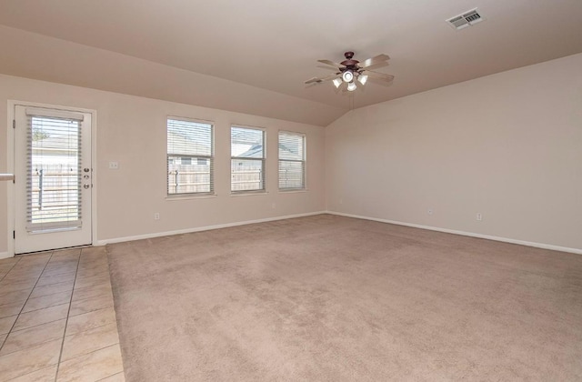 unfurnished living room with visible vents, baseboards, ceiling fan, vaulted ceiling, and light tile patterned floors