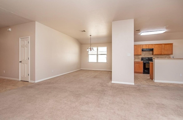 unfurnished living room with a notable chandelier, baseboards, light colored carpet, and visible vents