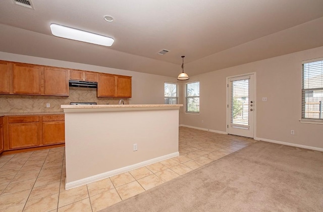 kitchen with visible vents, light carpet, tasteful backsplash, range hood, and light tile patterned floors