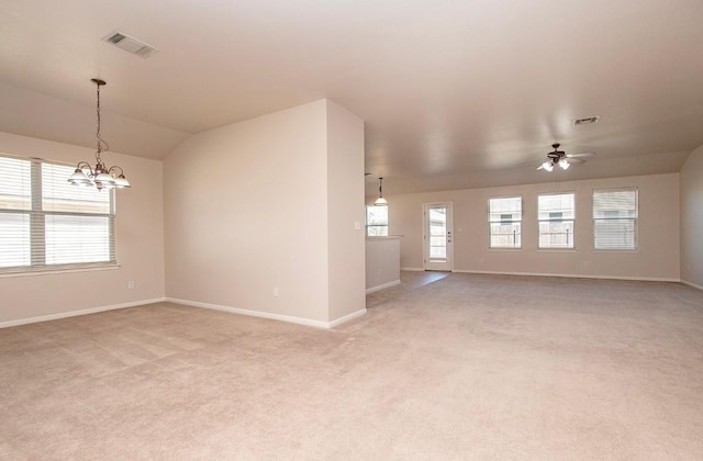 empty room featuring visible vents, plenty of natural light, light carpet, and ceiling fan with notable chandelier