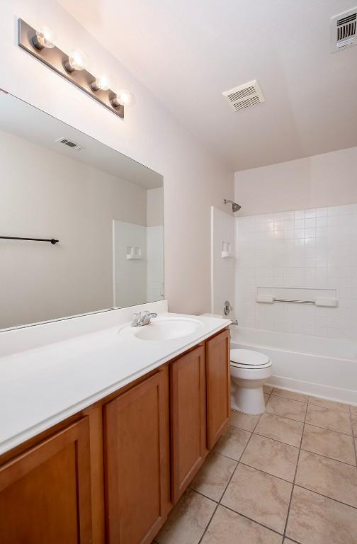 full bathroom with tile patterned floors, visible vents, and vanity