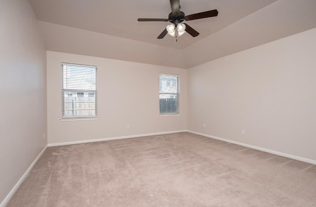 carpeted spare room with baseboards, a ceiling fan, and vaulted ceiling