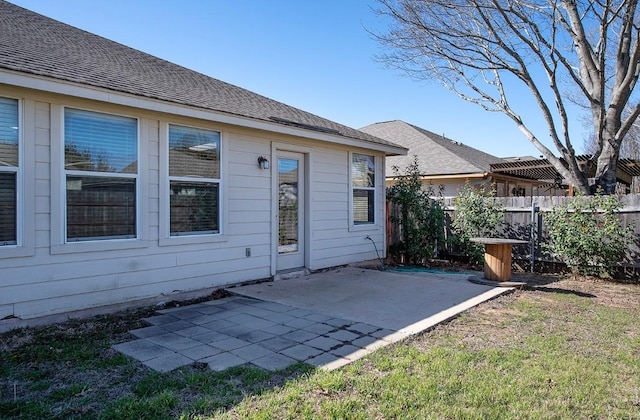 back of house featuring a patio, fence, and roof with shingles