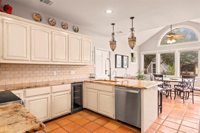 kitchen with beverage cooler, a peninsula, ceiling fan, stainless steel dishwasher, and tasteful backsplash