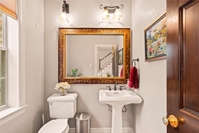 bathroom with toilet and baseboards