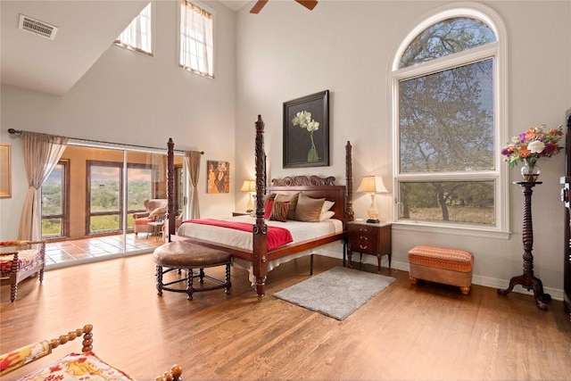 bedroom featuring visible vents, baseboards, wood finished floors, and access to outside