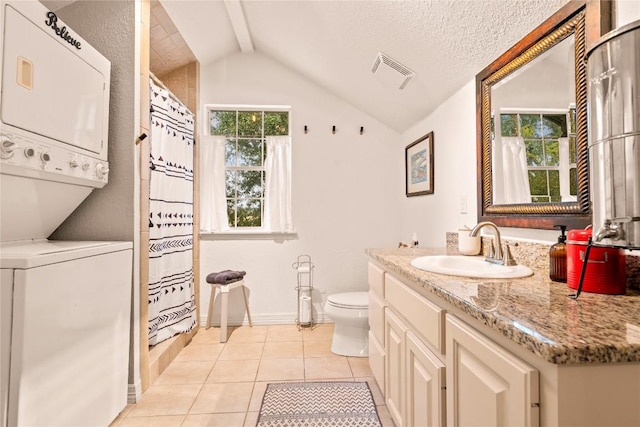 full bath with visible vents, vaulted ceiling with beams, stacked washer and dryer, tile patterned floors, and toilet