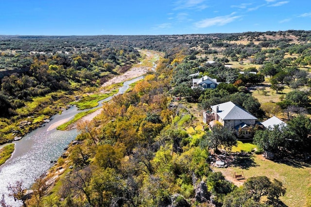 drone / aerial view with a view of trees and a water view