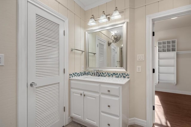 bathroom featuring vanity, baseboards, and wood finished floors