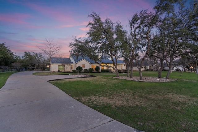 view of front of property with driveway and a yard