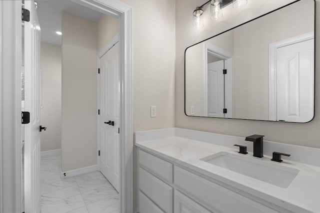 bathroom with baseboards, marble finish floor, and vanity