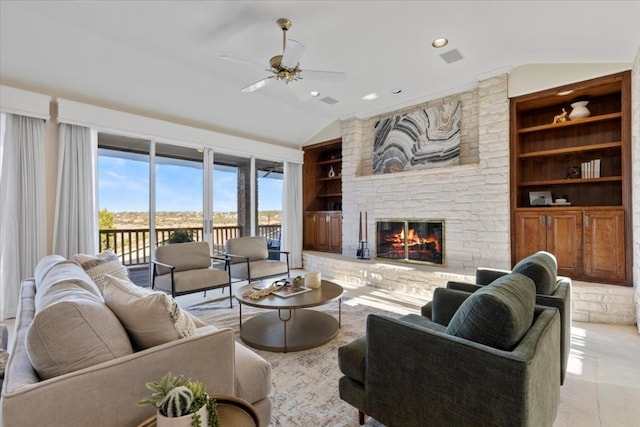 living area featuring a ceiling fan, built in features, a stone fireplace, light tile patterned flooring, and lofted ceiling