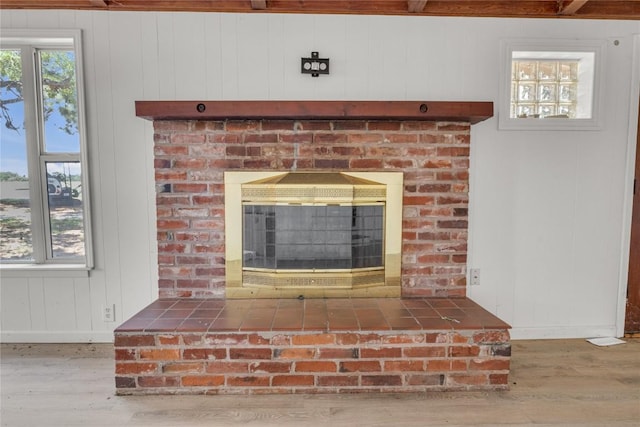 451 Pleasant Grove Rd, Elgin, TX 78621 - detailed view of wood finished floors, a brick fireplace, baseboards, and wooden walls