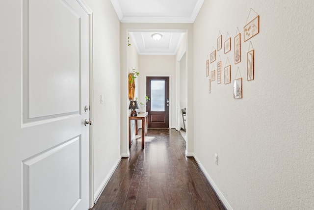 corridor with dark wood finished floors, crown molding, and baseboards