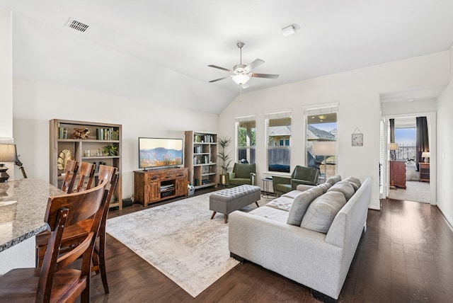 living area featuring vaulted ceiling, dark wood-style floors, visible vents, and ceiling fan