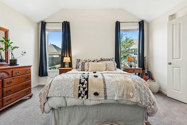 carpeted bedroom with lofted ceiling and baseboards