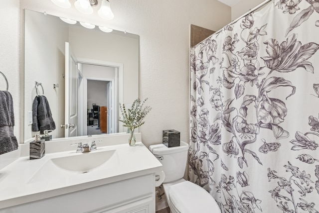 full bathroom featuring a shower with curtain, toilet, vanity, and a textured wall