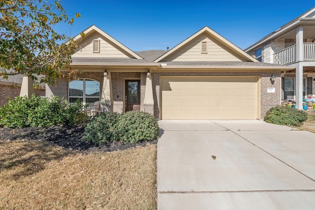 view of front of home with brick siding, an attached garage, and driveway