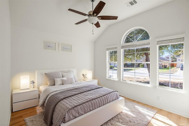 bedroom featuring a ceiling fan, lofted ceiling, wood finished floors, and visible vents