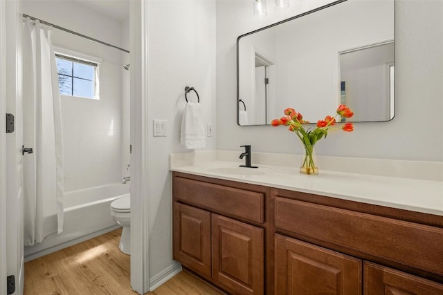 bathroom featuring shower / tub combo with curtain, toilet, wood finished floors, and vanity