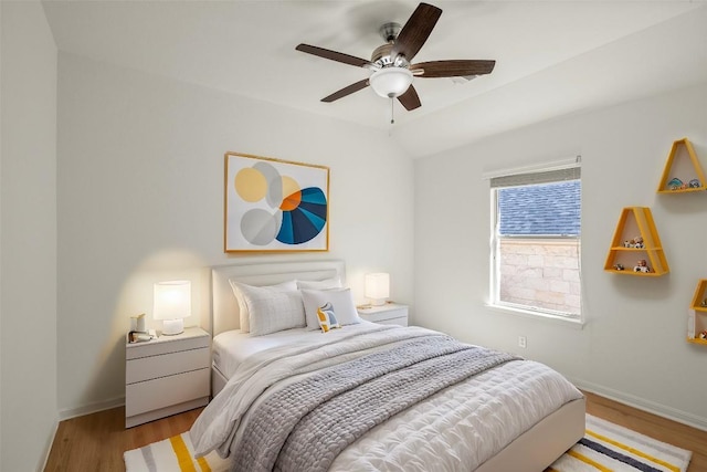 bedroom with ceiling fan, lofted ceiling, baseboards, and wood finished floors