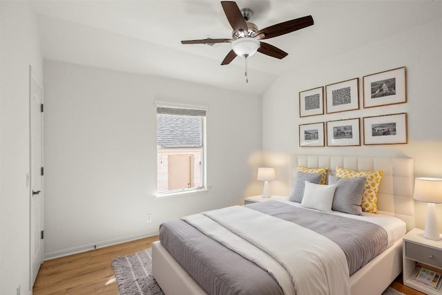 bedroom featuring baseboards, a ceiling fan, lofted ceiling, and wood finished floors