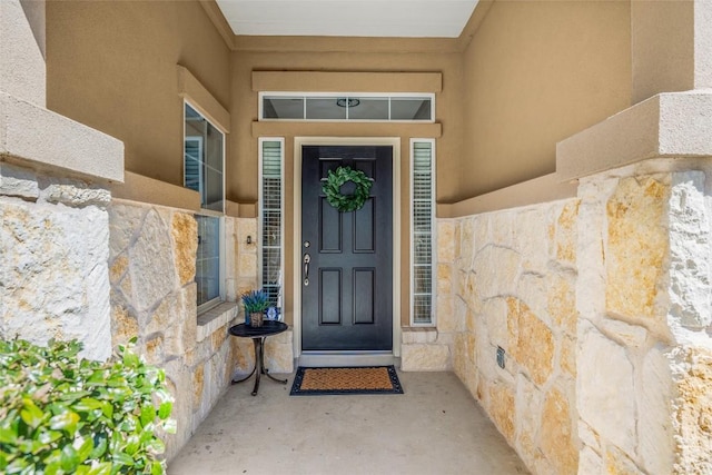 property entrance featuring stone siding and stucco siding