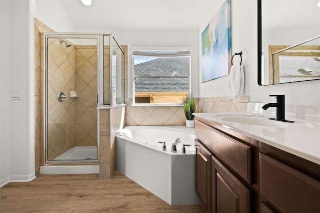 bathroom with vanity, wood finished floors, a shower stall, and a bath