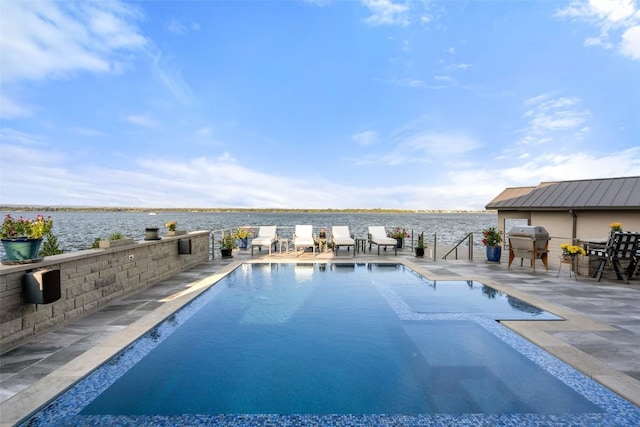 view of swimming pool with a patio, a fenced in pool, and a water view