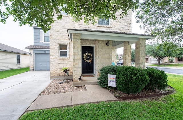 view of front of house featuring stone siding, concrete driveway, and a garage