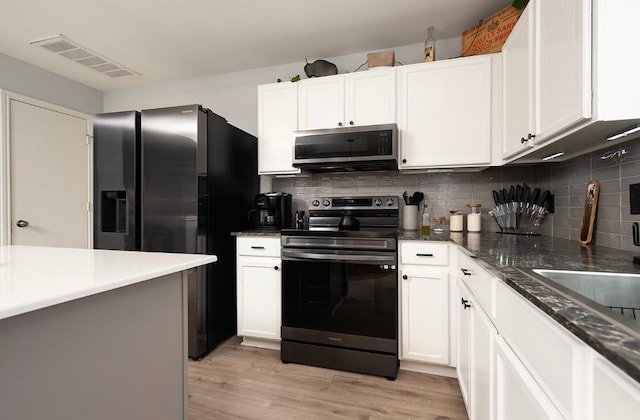 kitchen featuring tasteful backsplash, visible vents, stainless steel appliances, and light wood-style floors