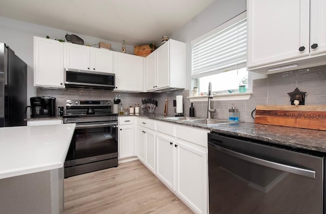 kitchen with a sink, tasteful backsplash, white cabinetry, and stainless steel appliances