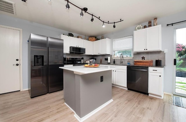 kitchen with tasteful backsplash, visible vents, light wood-type flooring, appliances with stainless steel finishes, and a sink