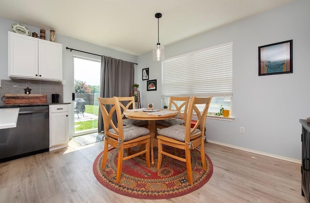 dining space with baseboards and light wood-type flooring